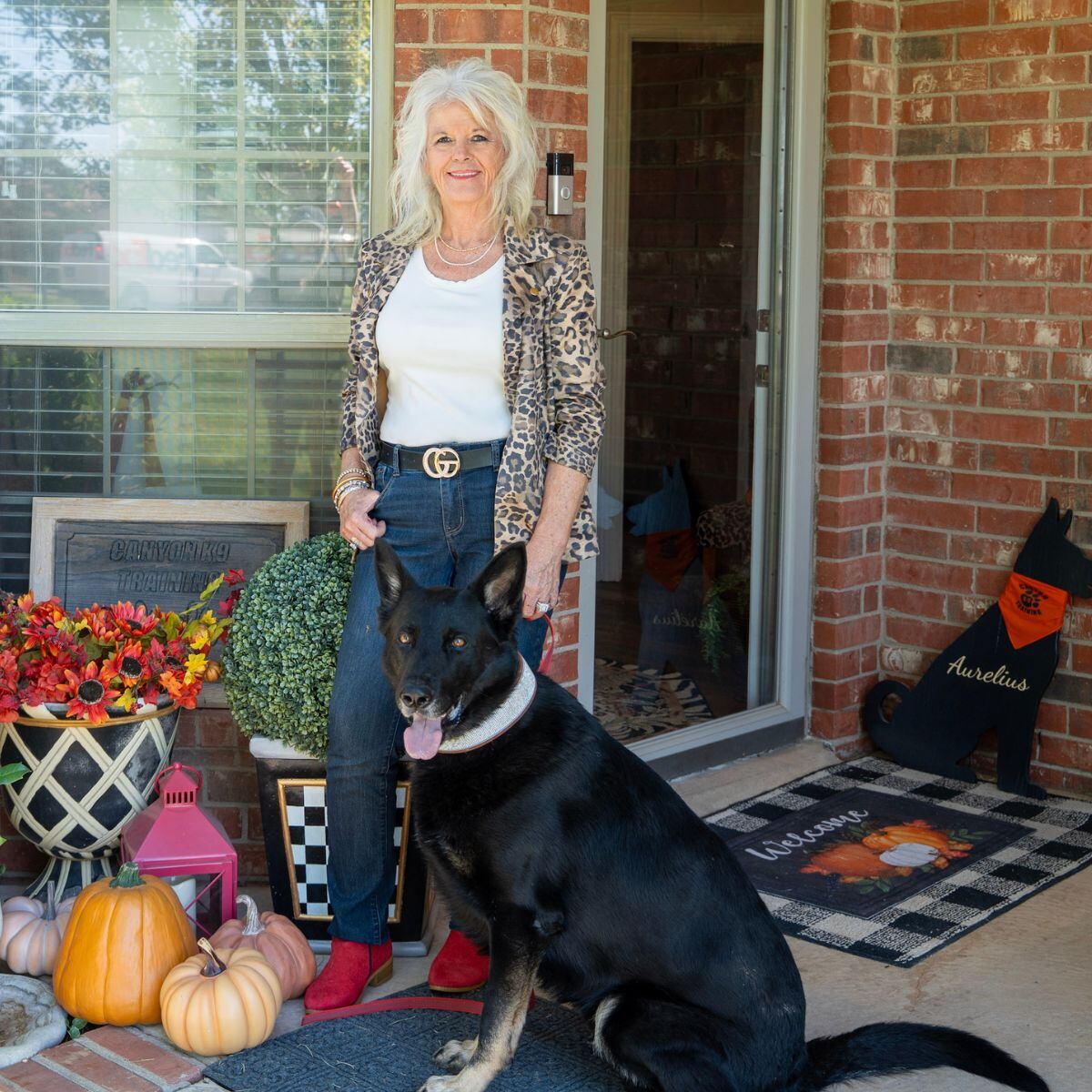 Lisa Price with a black shepherd at the entrance to Canyon K9 Training